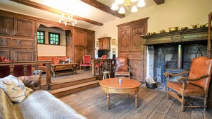 Una habitación tradicional con muebles de madera, chimenea y televisión.