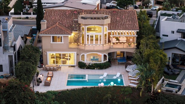 A large, multi-story house with a swimming pool, outdoor seating, and a balcony. - Luxury Pacific Beach Hilltop Rooftop Deck, Pool, 14-Person Hot Tub, 6BR/5BA (San Diego)