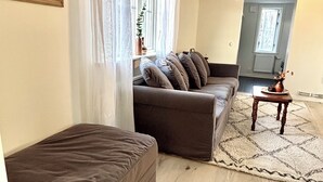A living room with a sofa, a small table, a rug, and a painting on the wall. - Charming accommodation near station - 11 minutes to Liseberg (Västra Götalands län)