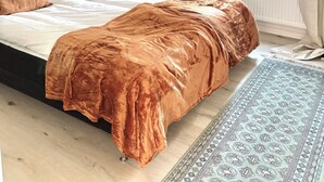 A bedroom with a bed, a nightstand, a lamp, a window, and a patterned rug. - Charming accommodation near station - 11 minutes to Liseberg (Västra Götalands län)