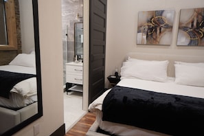 Ein Schlafzimmer mit Bett, Schminktisch, Nachttisch und Spiegel.