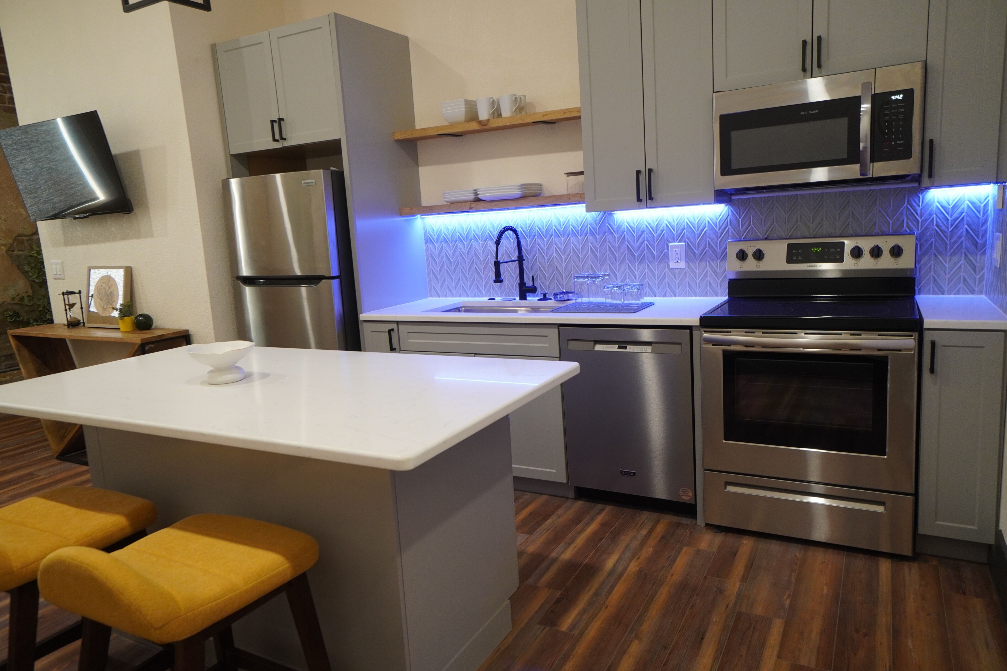 Una cocina moderna con electrodomésticos de acero inoxidable, una isla central y un microondas integrado.