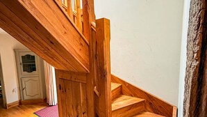 A wooden staircase with a skylight, wooden flooring, and a door in the background.