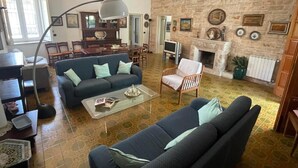 Ein Wohnzimmer mit einer Couch, Sesseln, einem Couchtisch, einem Kamin und einer Steinwand.