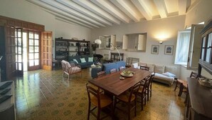 Ein großzügiger Wohnbereich mit Esstisch, Sofas und einer Küche im Hintergrund.