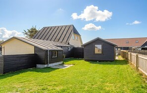 Uma área residencial com várias casas, gramado e céu aberto.