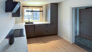 Eine Küche mit Fenster, Spüle und Tür.