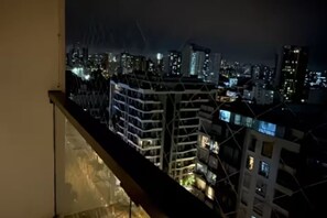 A nighttime cityscape with high-rise buildings and a construction crane. - Moderno apartamento para 5 con balcón, wifi y estacionamiento – Jesús María (lima)