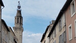 A street with historic buildings, a prominent tower, and a clear sky. - Charming apartment in Avignon's historic center (Avignon)