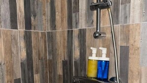 A shower with a rain showerhead and a soap dispenser on a shelf. - Charming apartment in Avignon's historic center (Avignon)