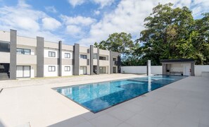 Un edificio moderno con piscina, un'area coperta e una scala che conduce ai piani superiori.