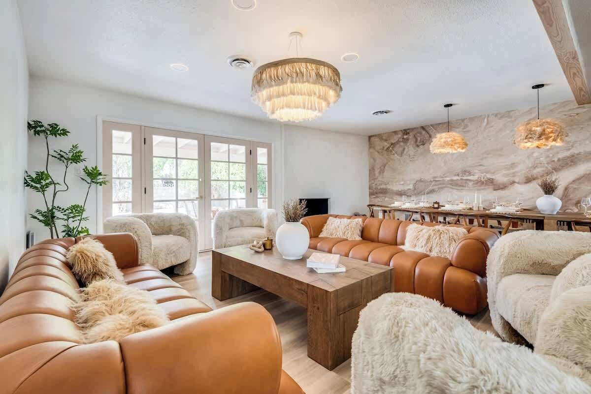 A modern living room with a sectional sofa, a coffee table, and a fireplace.