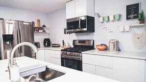 Una cocina moderna con electrodomésticos de acero inoxidable, horno empotrado y microondas.