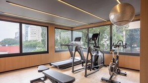 A gym with treadmills, an elliptical, and a stationary bike, large windows, and a wooden floor. - Condo. w/ Rooftop Pool, 270m fr/ the Metro, Jardins - Gabs (São Paulo)