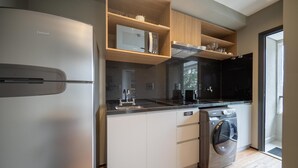 A modern kitchen with a refrigerator, microwave, oven, and washing machine. - Condo. w/ Rooftop Pool, 270m fr/ the Metro, Jardins - Gabs (São Paulo)