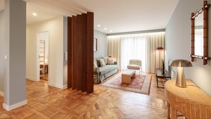 Una sala de estar moderna con piso de espiga, un sofá, una mesa de centro, una lámpara y una silla.