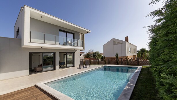 A modern two-story house with a swimming pool, wooden deck, and a fenced backyard. - Quinta Atia – Private Pool Hideaway (Caldas da Rainha)