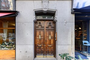 Una puerta doble de madera con el número 5 encima, ubicada en una pared de piedra.