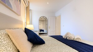 Ein Hotelzimmer mit Bett, Spiegel, Tür und Handtuchhalter.