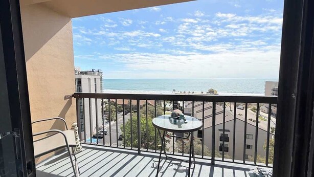 Ein Balkon mit Blick auf das Meer, einem runden Tisch und einem Stuhl.