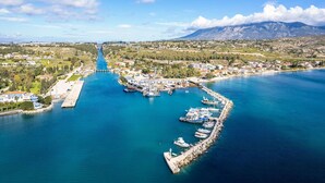 A coastal town with a marina, boats, and a bridge. - AG Stone Home - Idyllic Beachside Villa in Isthmia (Loutraki-Agioi Theodoroi)