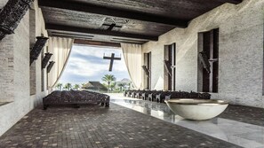 Eine Kapelle mit Backboden, Kirchenbänken und einem großen Taufbecken.