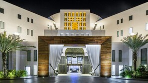 Ein Hotel Eingang mit modernem Design, gekennzeichnet durch ein großes Bogenportal und eine zentrale Leuchte.