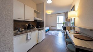 Una cocina moderna con armarios blancos, una estufa integrada y un comedor con mesa y sillas.