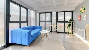 Un salon moderne avec un canapé bleu, une table ronde et un radiateur.