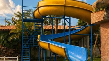 A water slide structure with a blue and yellow slide, leading into a pool.