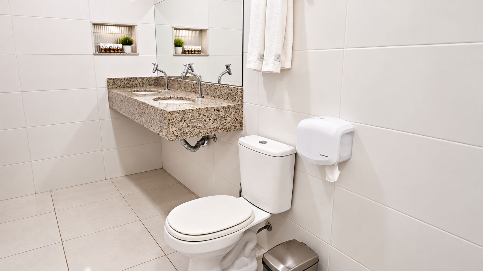 A bathroom with a toilet, a sink with a marble countertop, and a hand dryer.