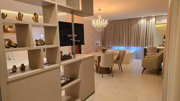 Uma sala de estar moderna com área de jantar, televisão e lustre.
