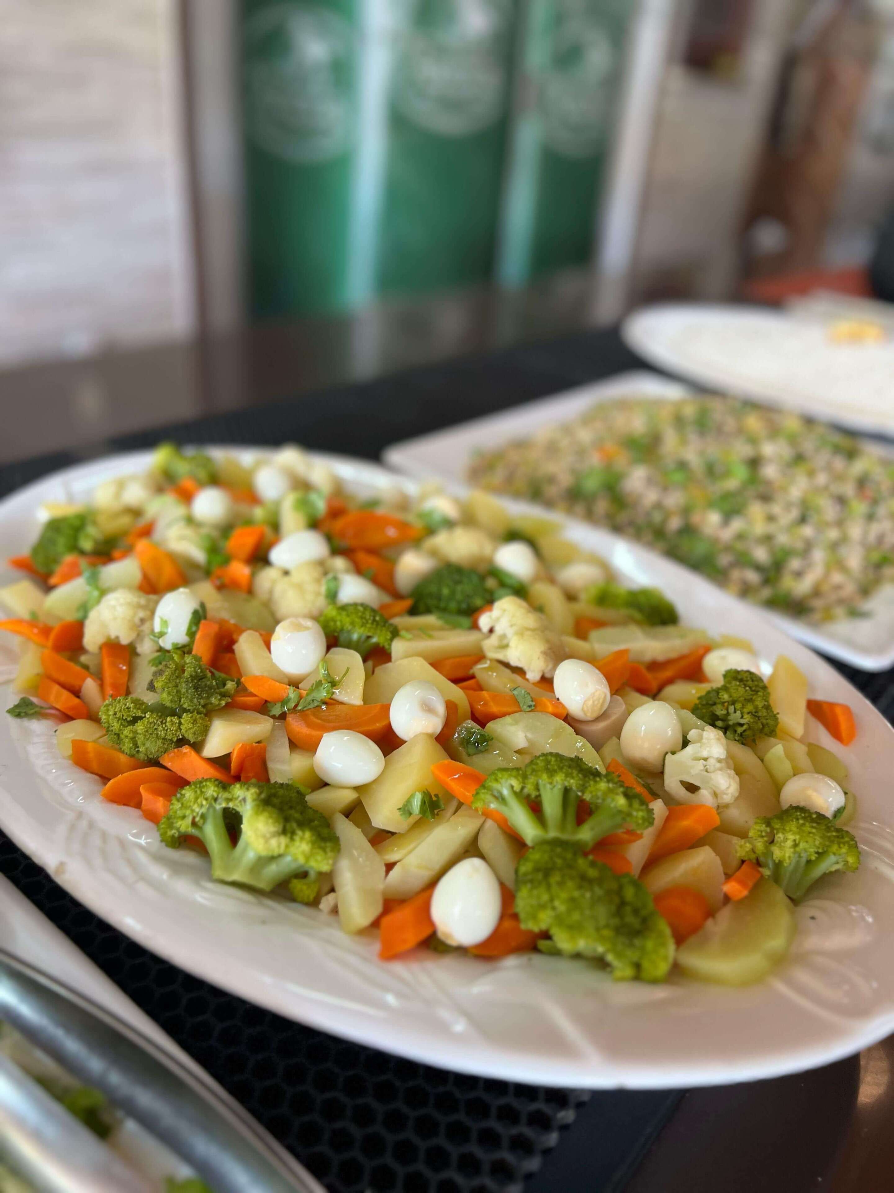 A plate of mixed vegetables including carrots, broccoli, cauliflower, and potatoes.