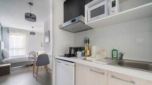 Een moderne keuken met witte kasten, een ingebouwde magnetron en een roestvrijstalen spoelbak.