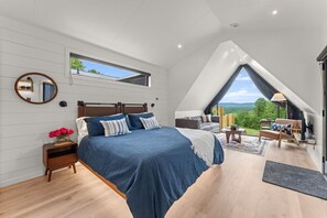 Een slaapkamer met een groot bed, een nachtkastje, een spiegel en een raam.