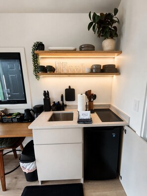 A compact kitchen with a built-in dishwasher, a coffee bar, and a small sink. - Orion A-Frame | King Suite, Fire Pit & Hot Tub (Berkeley Springs)