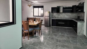 Una cocina moderna con armarios oscuros, encimera de mármol y horno empotrado.
