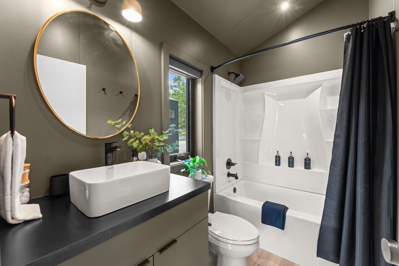 Une salle de bain moderne avec un grand miroir, un lavabo rectangulaire, des toilettes et un espace douche.