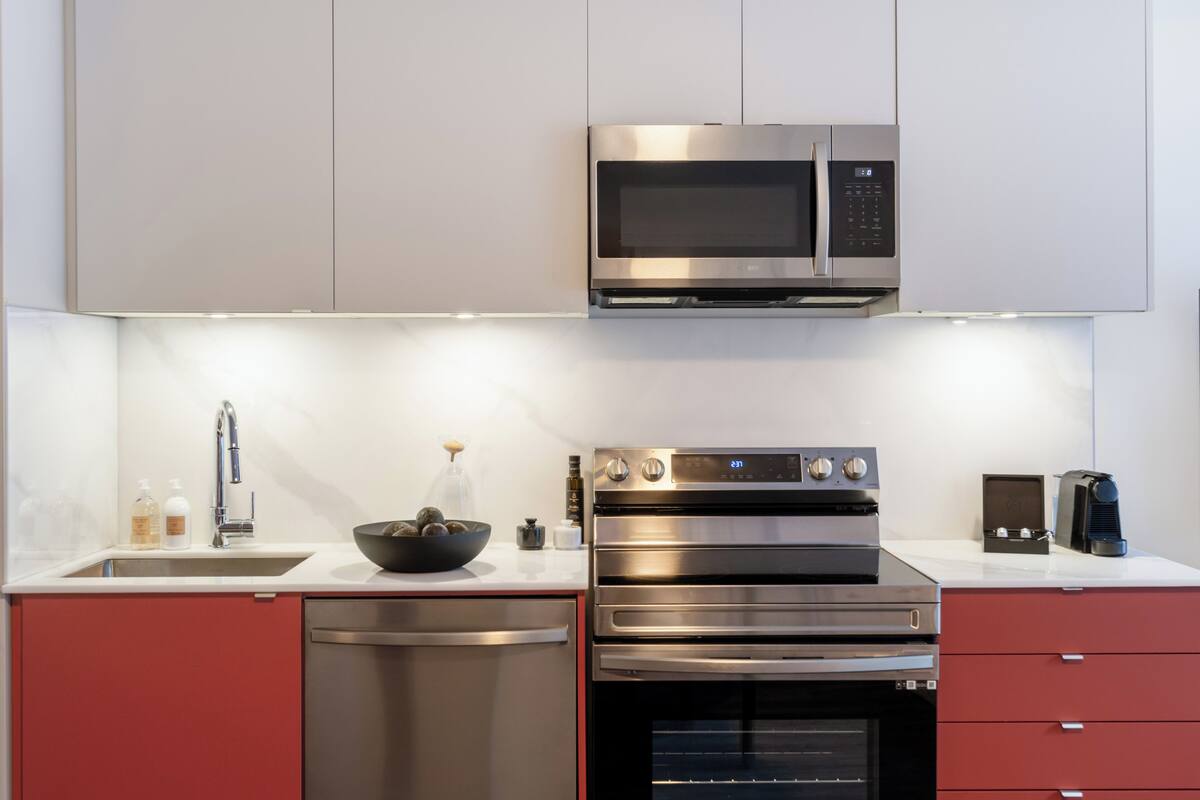 A modern kitchen with stainless steel appliances, a dishwasher, and a microwave.