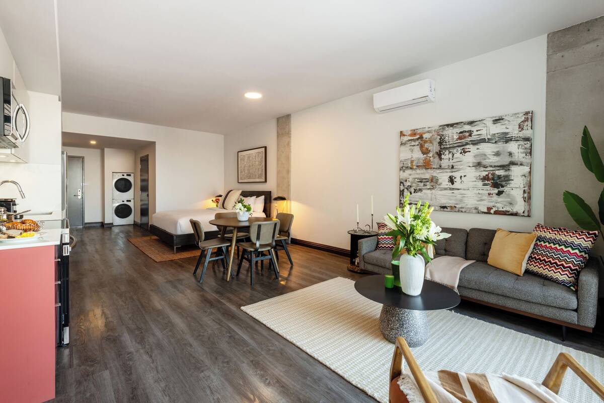 A modern living room with a sofa, coffee table, and dining area.