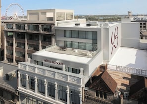 A hotel with a rooftop terrace, a Ferris wheel in the background, and a sign for 'MARRY ME'. - Brésoles Hotel (Montréal)