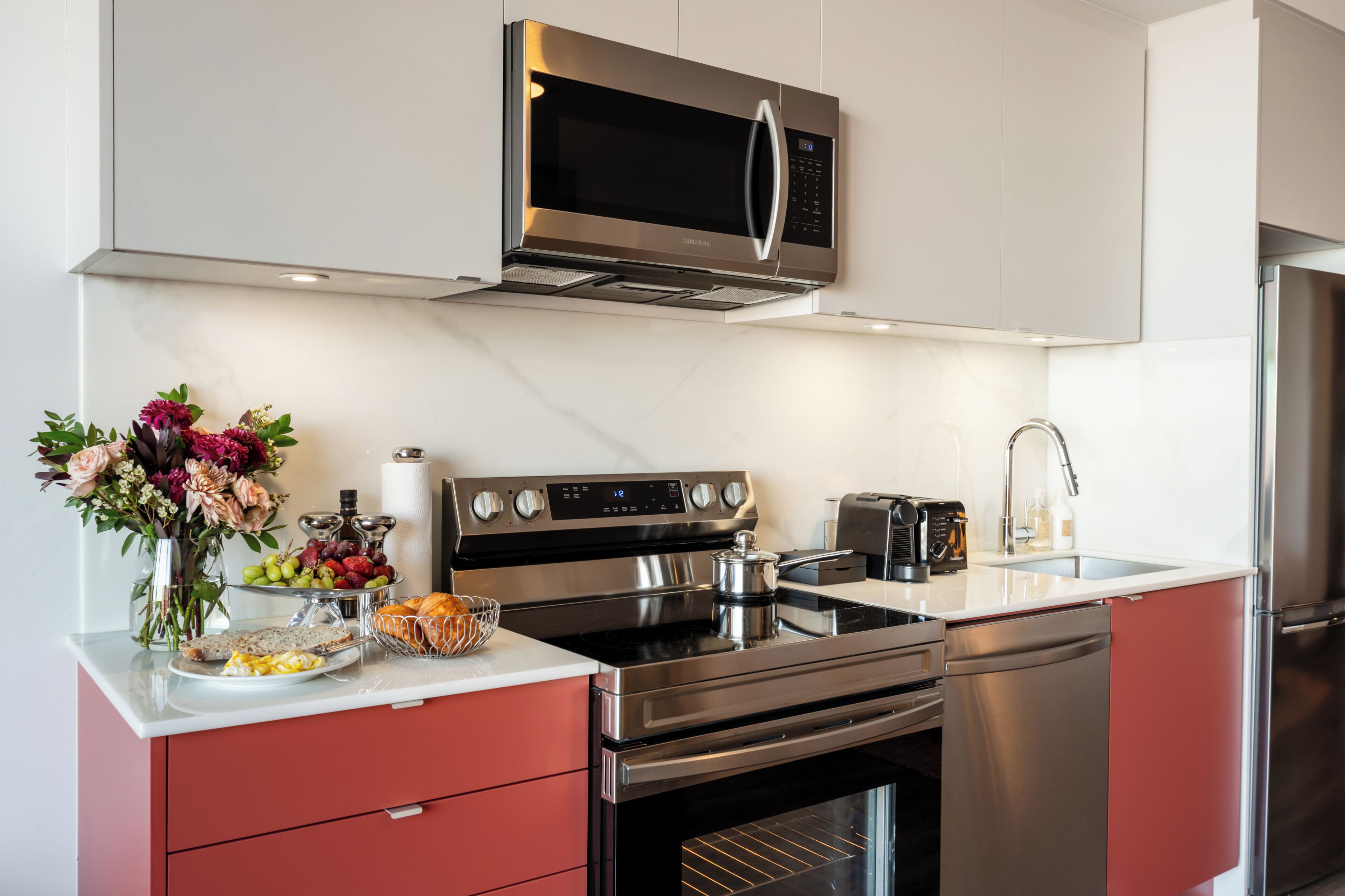 Una cocina moderna con electrodomésticos de acero inoxidable, horno empotrado y microondas.