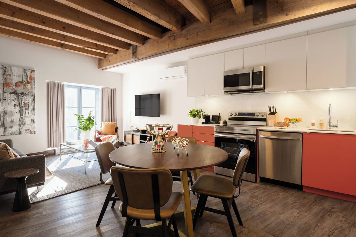 A modern kitchen with white cabinets, a stainless steel dishwasher, and a microwave.