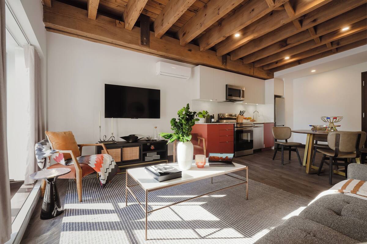 A modern living room with a sofa, coffee table, and a TV.