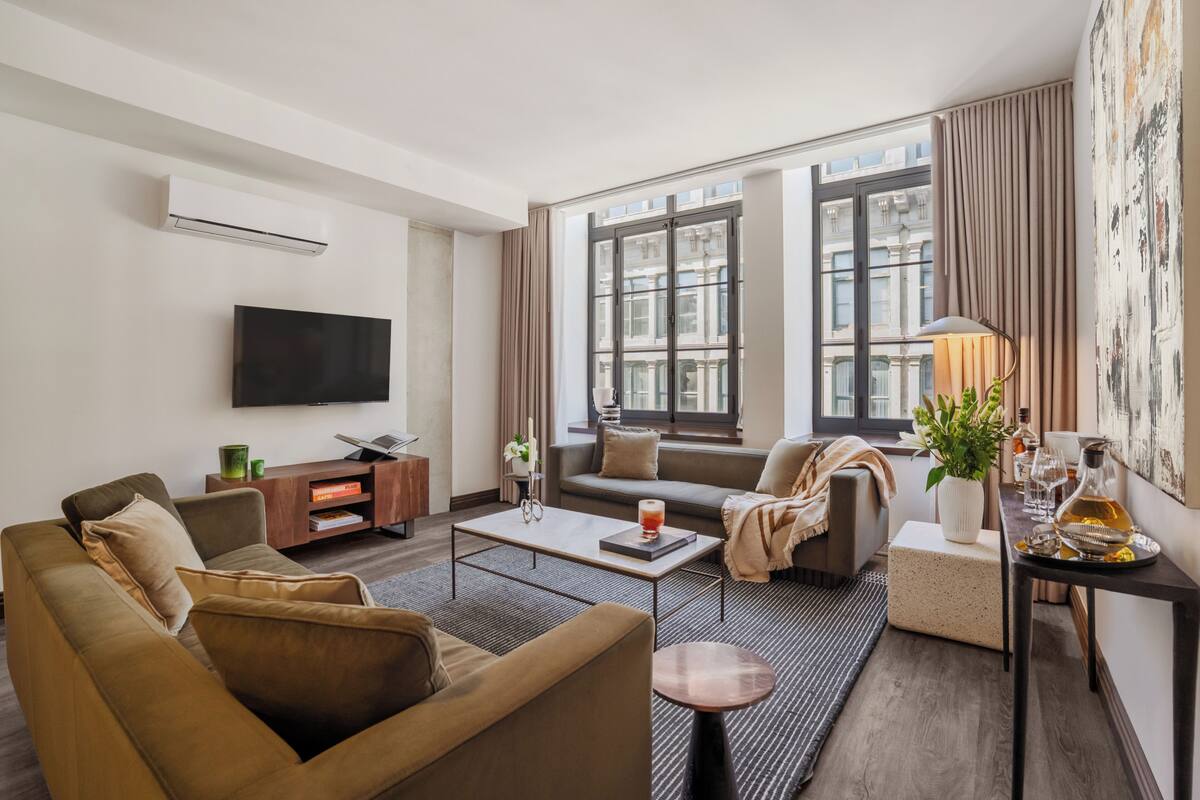 A modern living room with a sofa, coffee table, and a flat-screen TV.