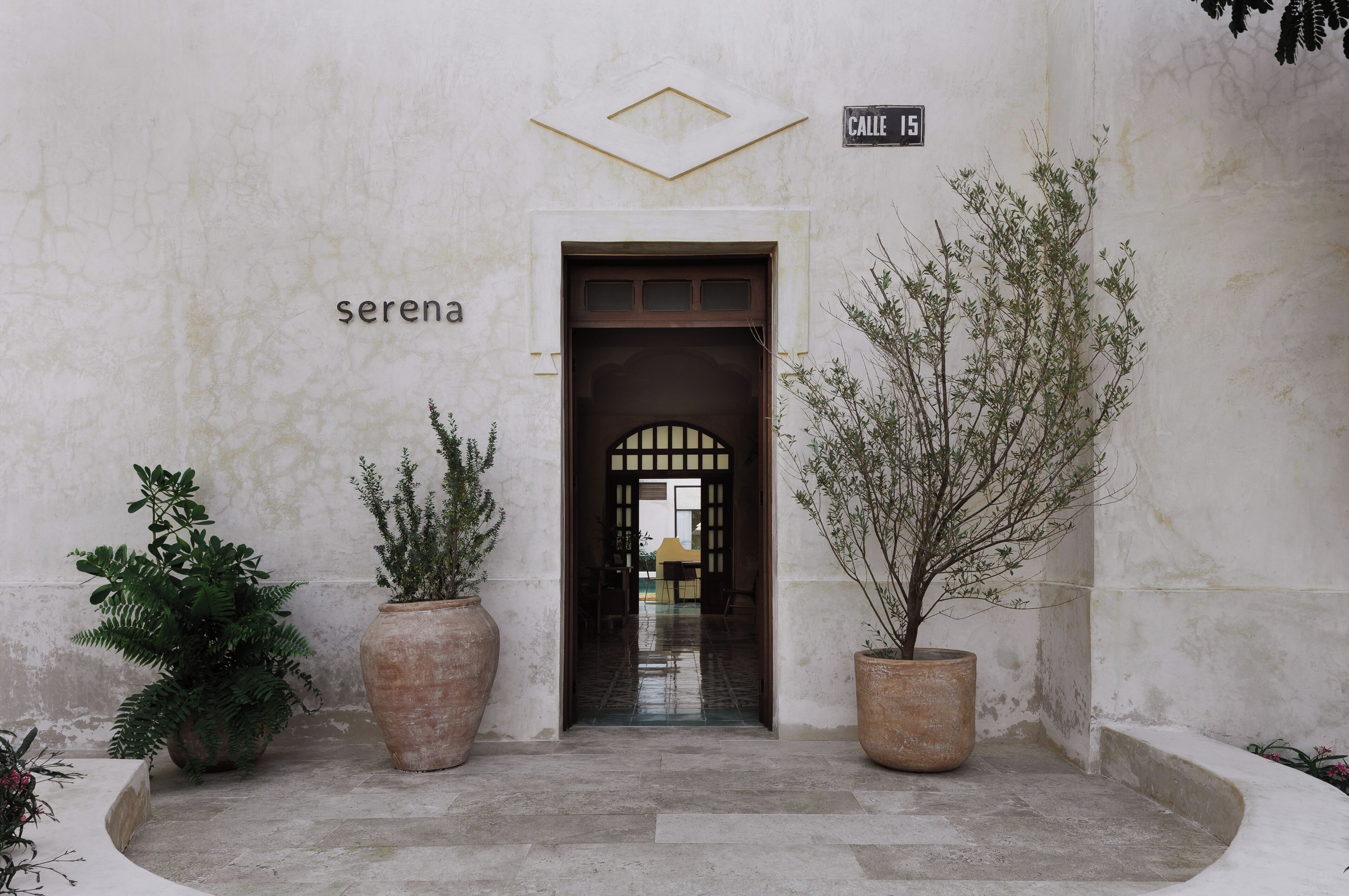 A building entrance with a sign reading 'serena' and 'Calle 15'.