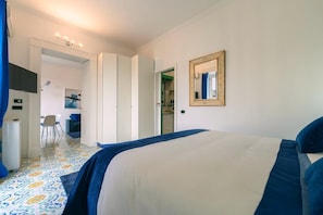 Une chambre avec un lit, un miroir et une vue sur la salle à manger.