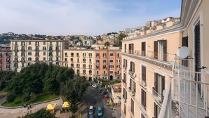 A multi-story building with balconies, a street view, and a distant cityscape. - Elegant Apartment for 4 in Chiaia - Capri View Terrace (Napoli)