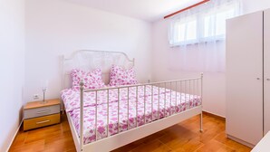 A bedroom with a single bed, a nightstand, a wardrobe, and a window with sheer curtains. - 2 bedroom cozy apartment in Medulin (Medulin)