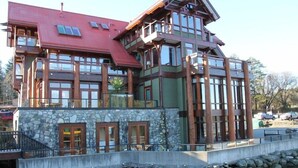 A multi-story building with a stone facade, large windows, and a red roof. - Seaside Ucluelet Hotel (Ucluelet)